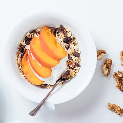 Peace, Love, and Granola breakfast with apricots in a white bowl.