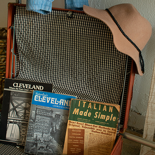 Clevelnd history books in antique suitcase with felt hat on top. Product photography for Relic Vintage.